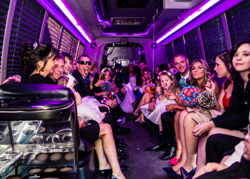 Family and friends of mixed ages seated together on a daytime party bus run