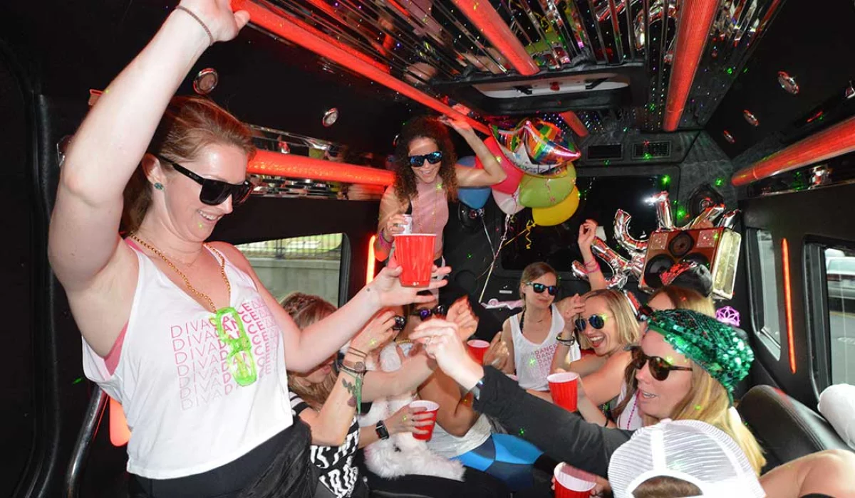 Birthday party bus hire — group dancing on a party bus decorated with balloons
